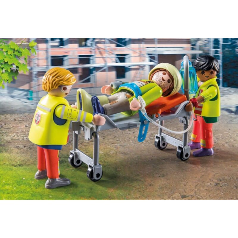 Two Playmobil paramedics pushing a stretcher with a patient into the ambulance.