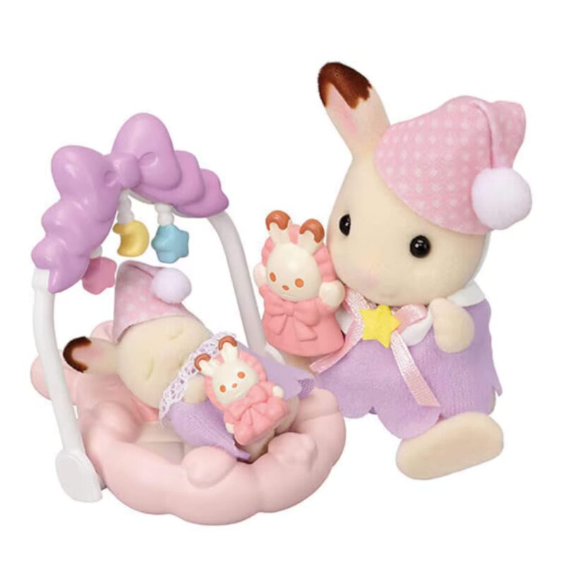 Chocolate Rabbit girl holding a toy while baby sibling sleeps in a pink cradle under a baby mobile from the Sylvanian Families Sleepy Dream Siblings set.