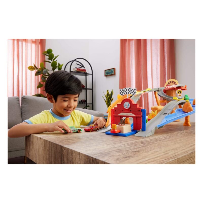 Kids racing Lightning McQueen and Chick Hicks on Cars track