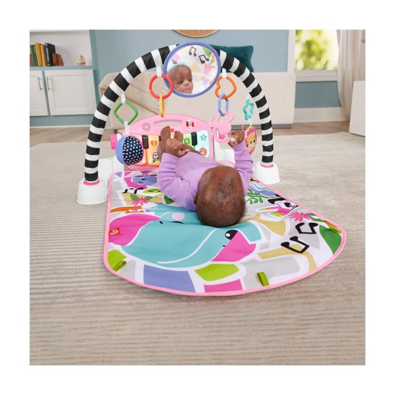 Baby lying under arch kicking the piano keys