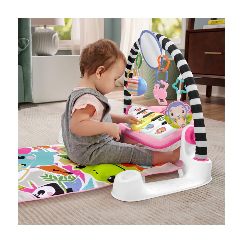 Baby sitting and pressing light-up piano keys