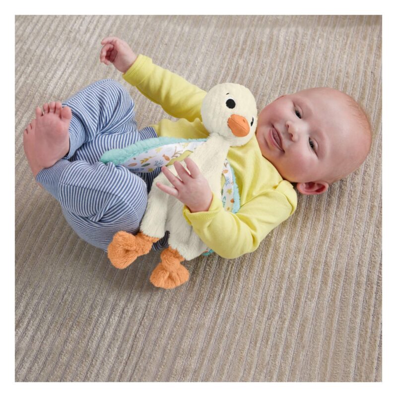 Infant lying down cuddling Snuggle Up Goose plush