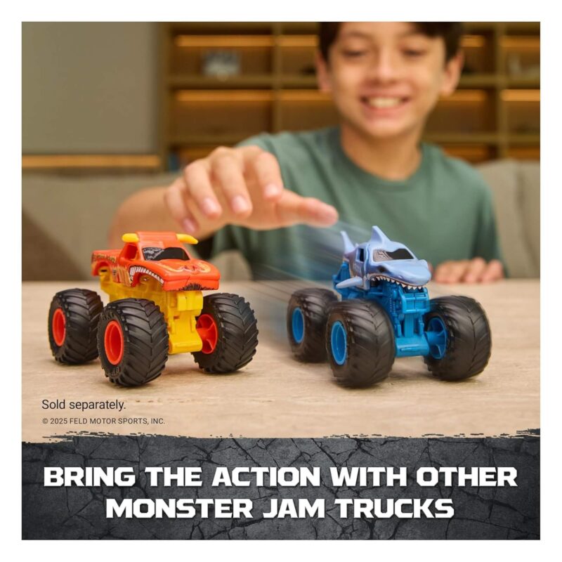 Child racing two Monster Jam trucks on tabletop